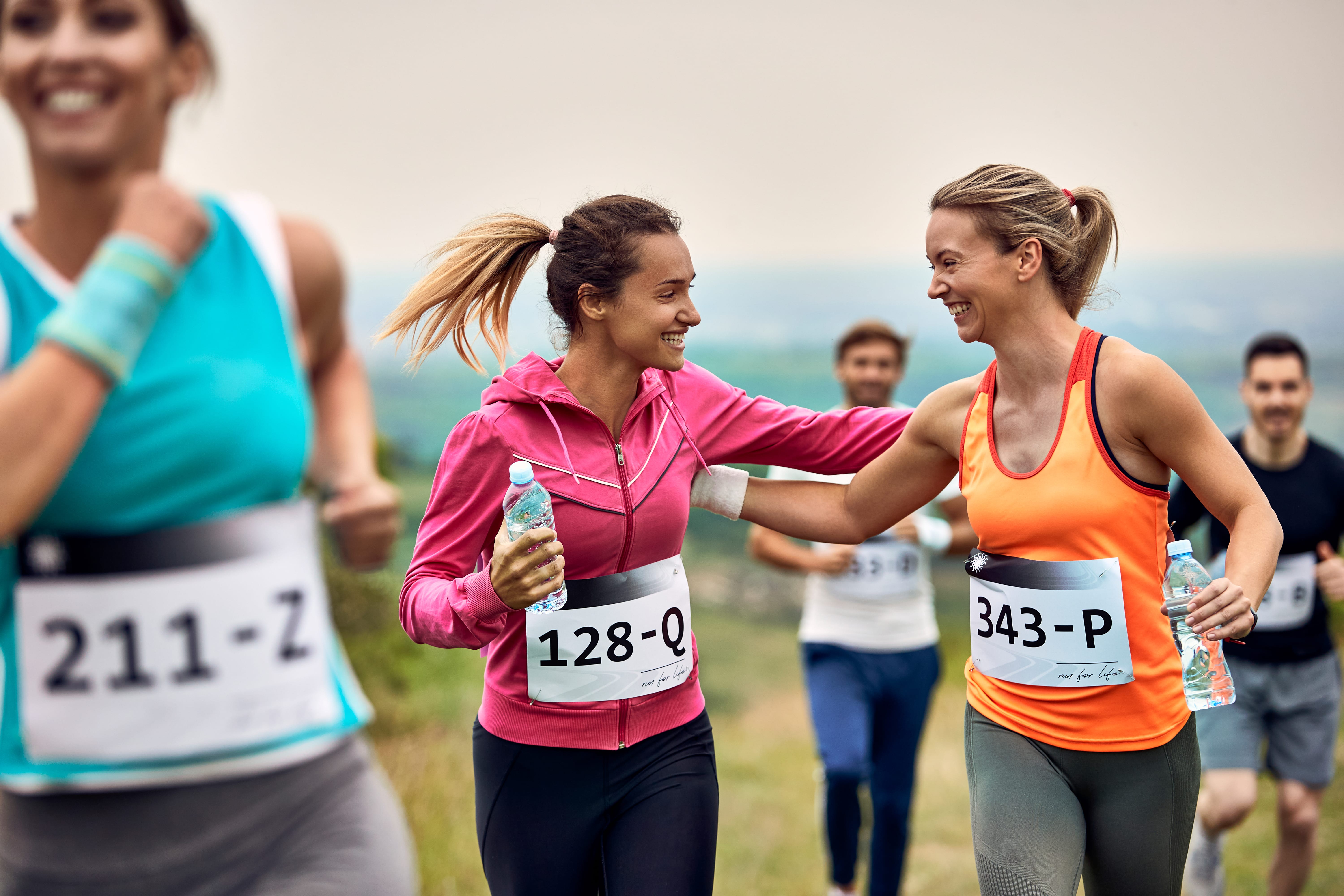happy-athletic-women-supporting-each-other-while-running-marathon-nature-min-min.jpg